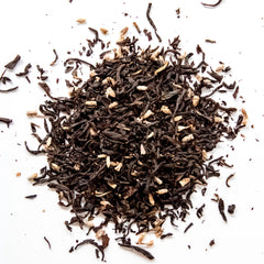 Loose leaf black tea with lavender buds and floral blend ingredients scattered on white surface, by Yerba Buena Tea Company.
